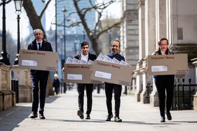 Labour Party campaigners on Whitehall during a stunt in which they carried envelopes labelled "Taxpayer's Money" while dressed as Chancellor of the Exchequer Rishi Sunak, Prime Minister Boris Johnson, Health Secretary Matt Hancock, and former Prime Minister David Cameron.