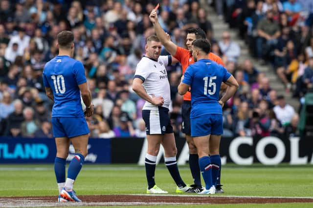 Referee Ben O'Keeffe brandishes the red card to denote that the Foul Play Review Officer had decided Scotland's Zander Fagerson's offence was worthy of a dismissal. (Photo by Ross Parker / SNS Group)