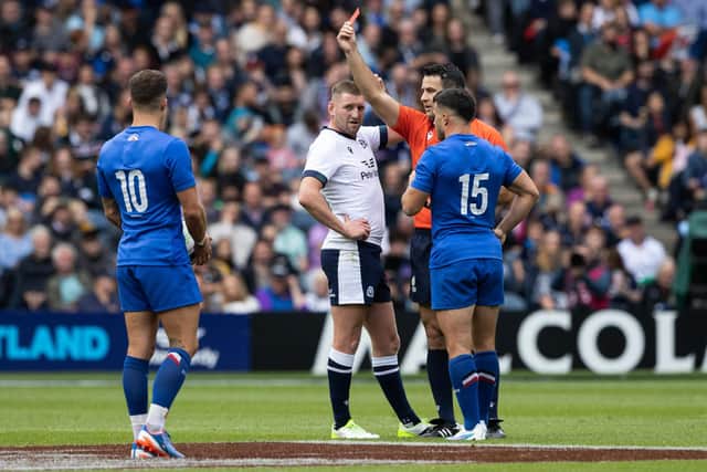 Referee Ben O'Keeffe brandishes the red card to denote that the Foul Play Review Officer had decided Scotland's Zander Fagerson's offence was worthy of a dismissal.  (Photo by Ross Parker / SNS Group)