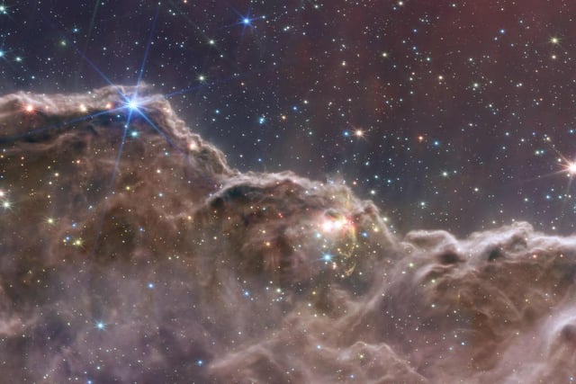 This image shows the edge of a nearby, young, star-forming region called NGC 3324 in the Carina Nebula. It reveals for the first time previously invisible areas of star birth.