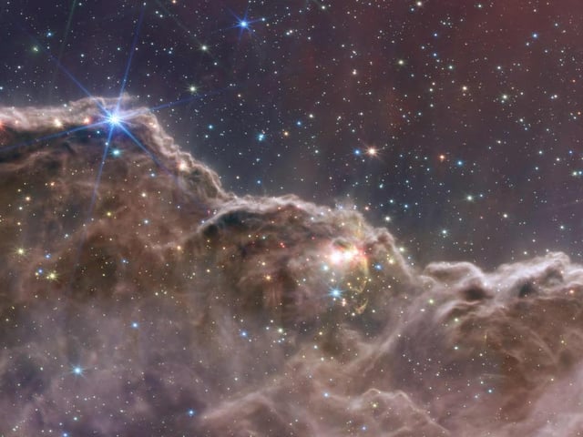 This image shows the edge of a nearby, young, star-forming region called NGC 3324 in the Carina Nebula. It reveals for the first time previously invisible areas of star birth.