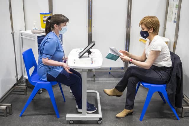 First Minister of Scotland Nicola Sturgeon (right) before receiving the first shot of the AstraZeneca vaccine, administered by staff nurse Elaine Anderson, at the NHS Louisa Jordan vaccine centre in the SSE Hydro in Glasgow. Picture: Jane Barlow/PA Wire