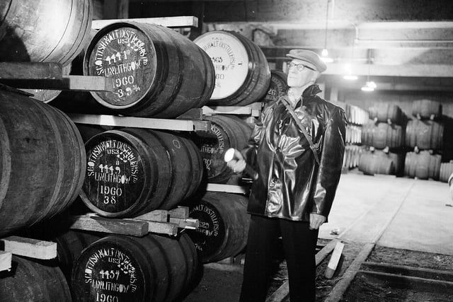 Night security officer Mr T Clydesdale in one of the warehouses of the St Magdalene Distillery, in Linlithgow, in 1962.