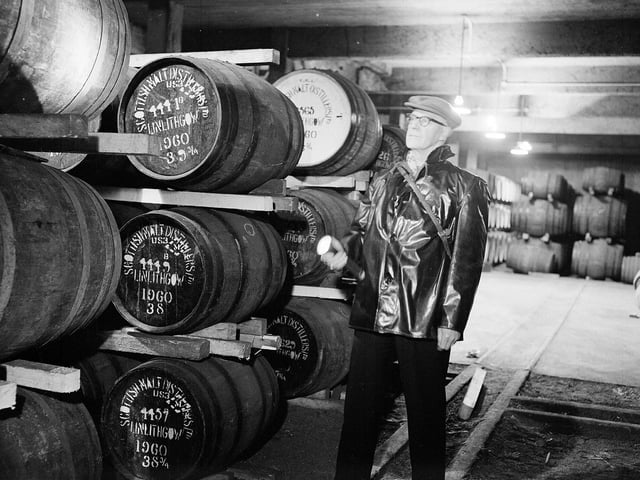 Night security officer Mr T Clydesdale in one of the warehouses of the St Magdalene Distillery, in Linlithgow, in 1962.