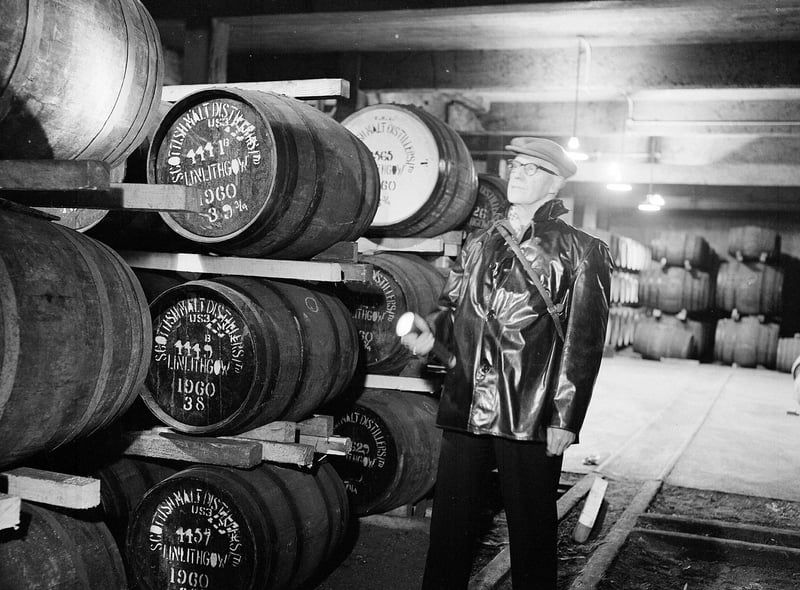 Night security officer Mr T Clydesdale in one of the warehouses of the St Magdalene Distillery, in Linlithgow, in 1962.
