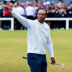 Tiger Woods acknowledges the crowd as he crosses the Swilcan Bridge at the Old Course, St Andrews. (Photo by Ross Parker / SNS Group)