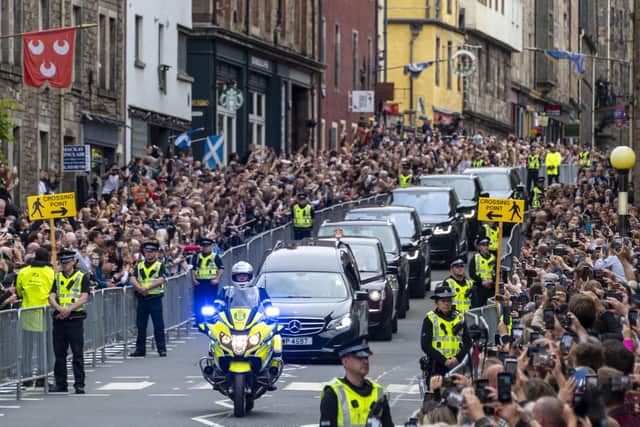 Thousands of people lined the streets to pay their respects as the hearse carrying the coffin of Her Majesty Queen Elizabeth travels along The Royal Mile in Edinburgh on Sunday, September 11.