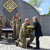 A serviceman offers the Ukrainian flag to the daughter of Yuriy Huk, a Ukrainian serviceman, killed during the Russian invasion of Ukraine, at his funeral service at the Saints Peter and Paul Garrison Church, in the western Ukrainian city of Lviv. Picure: Yuriy Dyachyshyn/AFP via Getty Images