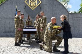 A serviceman offers the Ukrainian flag to the daughter of Yuriy Huk, a Ukrainian serviceman, killed during the Russian invasion of Ukraine, at his funeral service at the Saints Peter and Paul Garrison Church, in the western Ukrainian city of Lviv. Picure: Yuriy Dyachyshyn/AFP via Getty Images