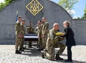 A serviceman offers the Ukrainian flag to the daughter of Yuriy Huk, a Ukrainian serviceman, killed during the Russian invasion of Ukraine, at his funeral service at the Saints Peter and Paul Garrison Church, in the western Ukrainian city of Lviv. Picure: Yuriy Dyachyshyn/AFP via Getty Images