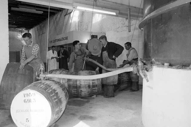 Workers filling barrels with whisky at McNabs Lochside Distillery, in Montrose, in September 1959.