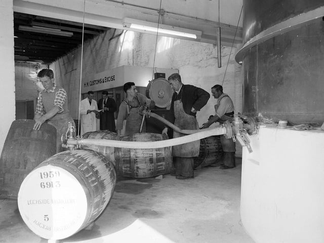 Workers filling barrels with whisky at McNabs Lochside Distillery, in Montrose, in September 1959.