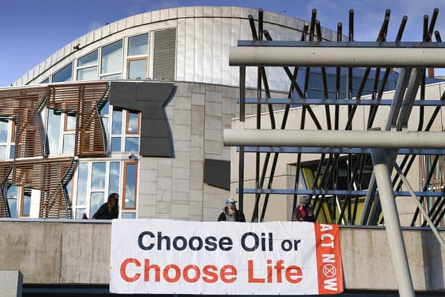 Extinction Rebellion activists protest on the roof of the Scottish Parliament where they have hung a banner saying 'Choose Oil or Choose Life'. Picture: Jeff J Mitchell/Getty Images