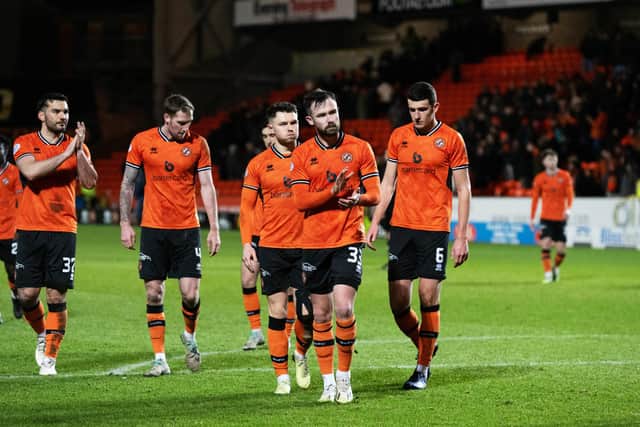 The dejected Dundee United players trudge off a full time.