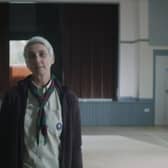 A screenshot of the party political broadcast including a woman in full Scout uniform