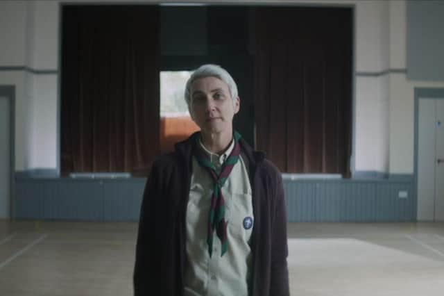 A screenshot of the party political broadcast including a woman in full Scout uniform