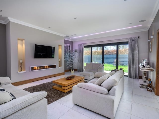 Lounge with glass bi-fold doors into the gardens, remote controlled fire, integrated ceiling speakers, and mood lighting.