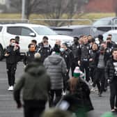 Motherwell's players walk over after arriving in their cars at Celtic Park.