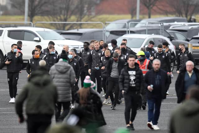 Motherwell's players walk over after arriving in their cars at Celtic Park.