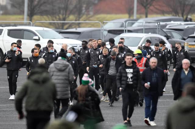 Motherwell's players walk over after arriving in their cars at Celtic Park.