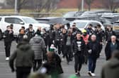 Motherwell's players walk over after arriving in their cars at Celtic Park.