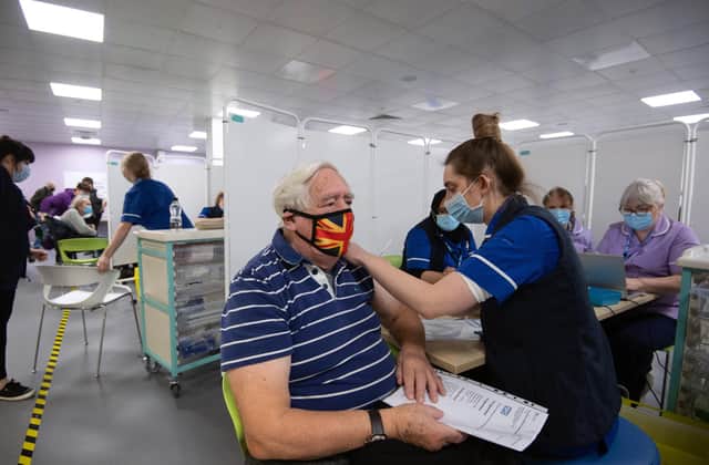 Robert Williams, 84, receives a vaccine at one of the seven mass vaccination centres already opened in England.