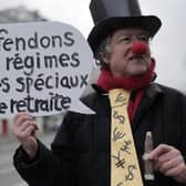 A disguised protestor holding a placard reading "let's defend our very special pension regimes" poses before a demonstration in Paris. Picture: AP Photo/Lewis Joly