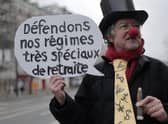 A disguised protestor holding a placard reading "let's defend our very special pension regimes" poses before a demonstration in Paris. Picture: AP Photo/Lewis Joly