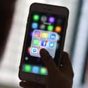 This photo illustration taken on March 22, 2018 shows a woman looking at Social Networking applications Facebook, Instagram, Snapchat, Whatsapp, Twitter, Messenger and Linkedin on a smartphone in Kuala Lumpur. (Photo by Manan VATSYAYANA / AFP) (Photo by MANAN VATSYAYANA/AFP via Getty Images)