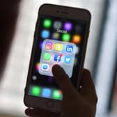 This photo illustration taken on March 22, 2018 shows a woman looking at Social Networking applications Facebook, Instagram, Snapchat, Whatsapp, Twitter, Messenger and Linkedin on a smartphone in Kuala Lumpur. (Photo by Manan VATSYAYANA / AFP) (Photo by MANAN VATSYAYANA/AFP via Getty Images)