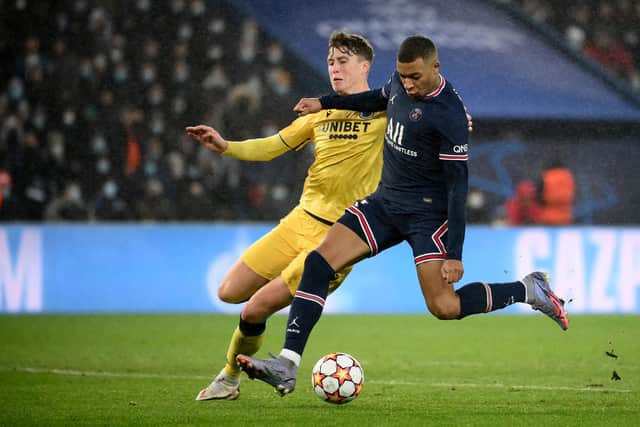 Scotland and Club Brugge defender Jack Hendry tangles with PSG forward Kylian Mbappe in a Champions League encounter. (Photo by FRANCK FIFE/AFP via Getty Images)
