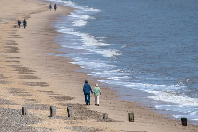 People social distancing as they walk along the beach at Gorleston-on-Sea in Norfolk
