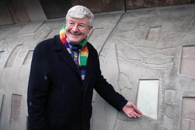 Robin Harper, seen in his trademark multi-coloured scarf in 2009, points to some new quotes added to the Canongate wall of quotations at the Scottish Parliament (Picture: David Cheskin/PA)
