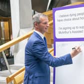 Liam McArthur MSP signs a pledge card in support of his Assisted Dying Bill at the Scottish Parliament (Picture: Jane Barlow/PA)