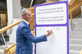 Liam McArthur MSP signs a pledge card in support of his Assisted Dying Bill at the Scottish Parliament (Picture: Jane Barlow/PA)