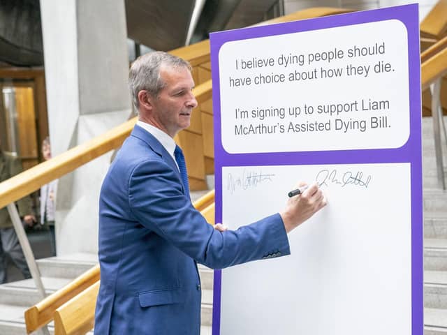 Liam McArthur MSP signs a pledge card in support of his Assisted Dying Bill at the Scottish Parliament (Picture: Jane Barlow/PA)