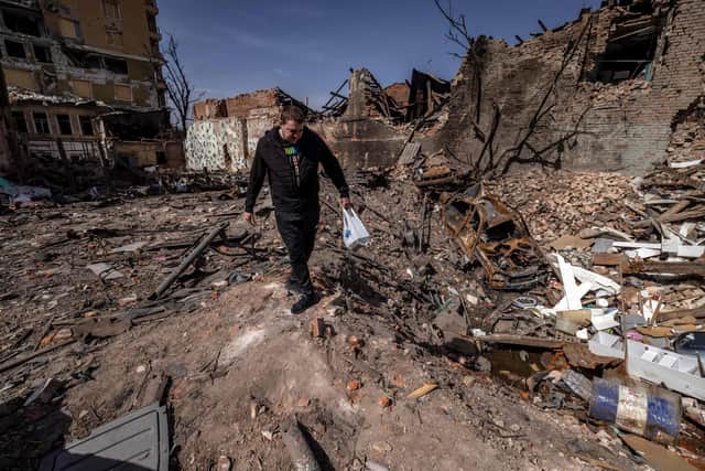 A man walks in a destroyed street of the eastern Ukraine city of Kharkiv on Saturday, as Ukraine said today Russian forces were making a "rapid retreat" from northern areas around the capital Kyiv and the city of Chernigiv. (Photo by FADEL SENNA/AFP via Getty Images)