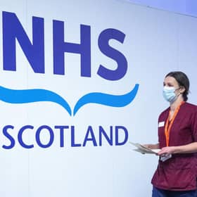 A member of the vaccination team walks past an NHS sign at the coronavirus mass vaccine centre at the Edinburgh International Conference Centre earlier this year. Picture: Jane Barlow - Pool/Getty Images