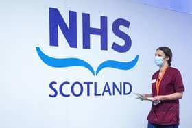 A member of the vaccination team walks past an NHS sign at the coronavirus mass vaccine centre at the Edinburgh International Conference Centre earlier this year. Picture: Jane Barlow - Pool/Getty Images