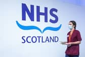 A member of the vaccination team walks past an NHS sign at the coronavirus mass vaccine centre at the Edinburgh International Conference Centre earlier this year. Picture: Jane Barlow - Pool/Getty Images