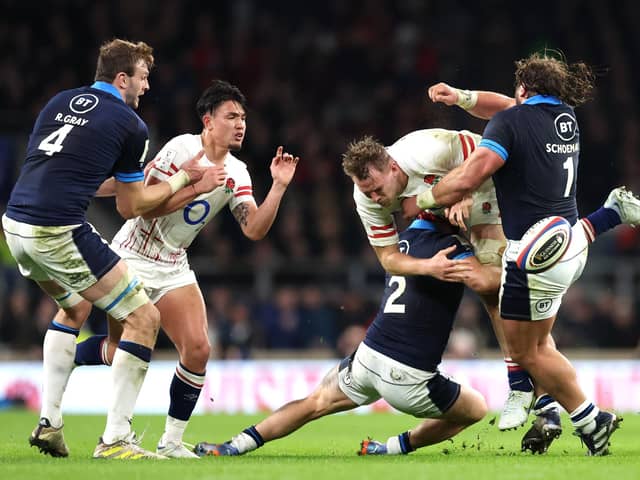 Alex Dombrandt of England is tackled by Scotland duo George Turner and Pierre Schoeman.