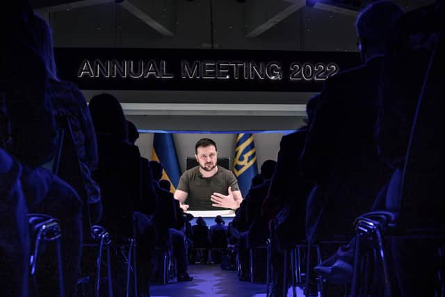 Ukrainian President Volodymyr Zelensky is seen on a giant screen during his address by video conference as part of the World Economic Forum (WEF) annual meeting in Davos on May 23, 2022. (Photo by Fabrice COFFRINI via Getty Images)