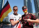 Germany fans pose for a photo wearing a rainbow wristband in Doha, Qatar.