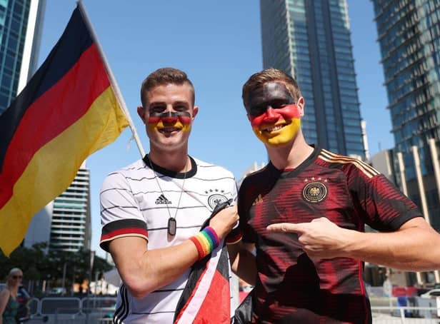 Germany fans pose for a photo wearing a rainbow wristband in Doha, Qatar.