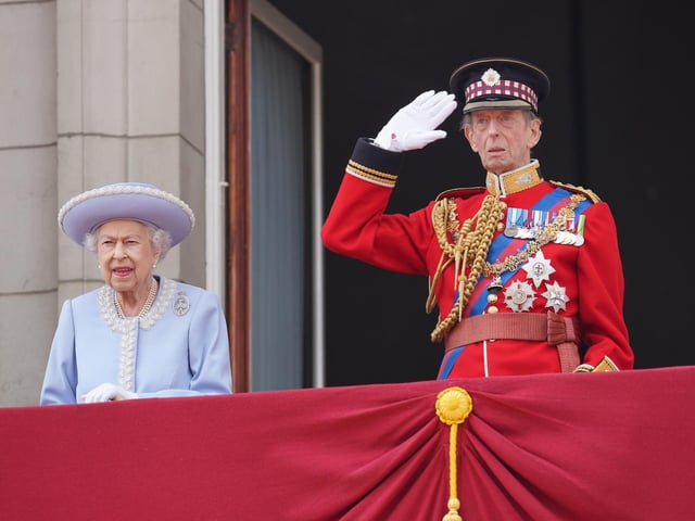Queen Elizabeth II and the Duke of Kent watch from the balcony.