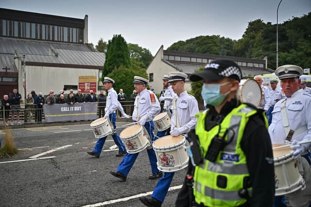 An orange parade passes St Benedict's catholic church in Easterhouse where a counter protest by Call It Out gathered on September 18, 2021 in Glasgow, Scotland. Around 13,000 marchers are expected to take part in more than 50 parades through the city centre heading to Glasgow Green to celebrate the 200th anniversary of the first Battle of the Boyne parade in Glasgow. (Photo by Jeff J Mitchell/Getty Images)