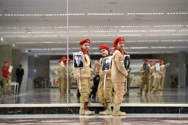 Members of Russia's Yunarmiya (Young Army) youth patriotic movement hold photographs of Second World War veterans before a gala in the Grand Kremlin Palace (Picture: Yuri Kadobnov/AFP via Getty Images)