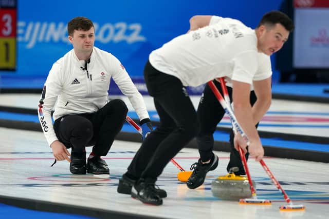 Great Britain's Bruce Mouat (left) releases the stone as Hammy McMillan and Bobby Lammie (hidden) sweep the stone in the final against Sweden.