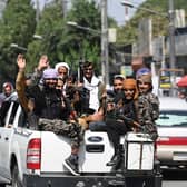 Taliban fighters wave as they patrol in a convoy along a street in Kabul. Picture: Aamir Qureshi/AFP via Getty Images