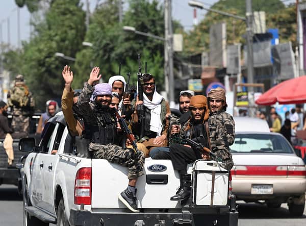 Taliban fighters wave as they patrol in a convoy along a street in Kabul. Picture: Aamir Qureshi/AFP via Getty Images